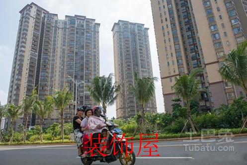 　　资料图：市民在海口市区某地产项目前路过。 中新社记者 骆云飞 摄